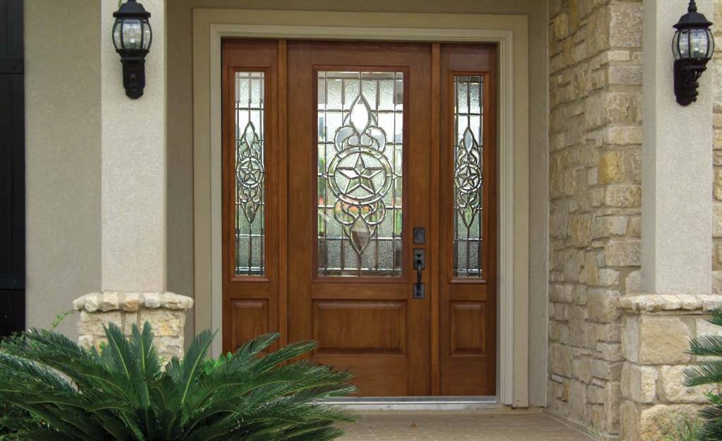 Wood-tone front door with detailed glass and sidelites.
