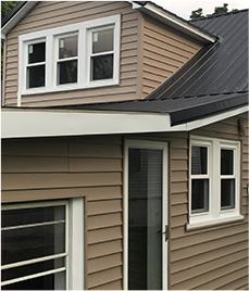 Energy efficient windows installed on the second story of a brown house