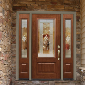 Wood-grain fiberglass front door with decorative glass and sidelites in a light tan brick home.