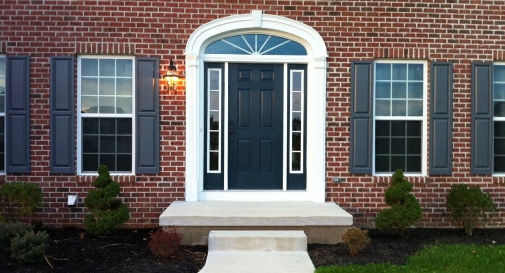 Black front door with sidelites on a brick house.