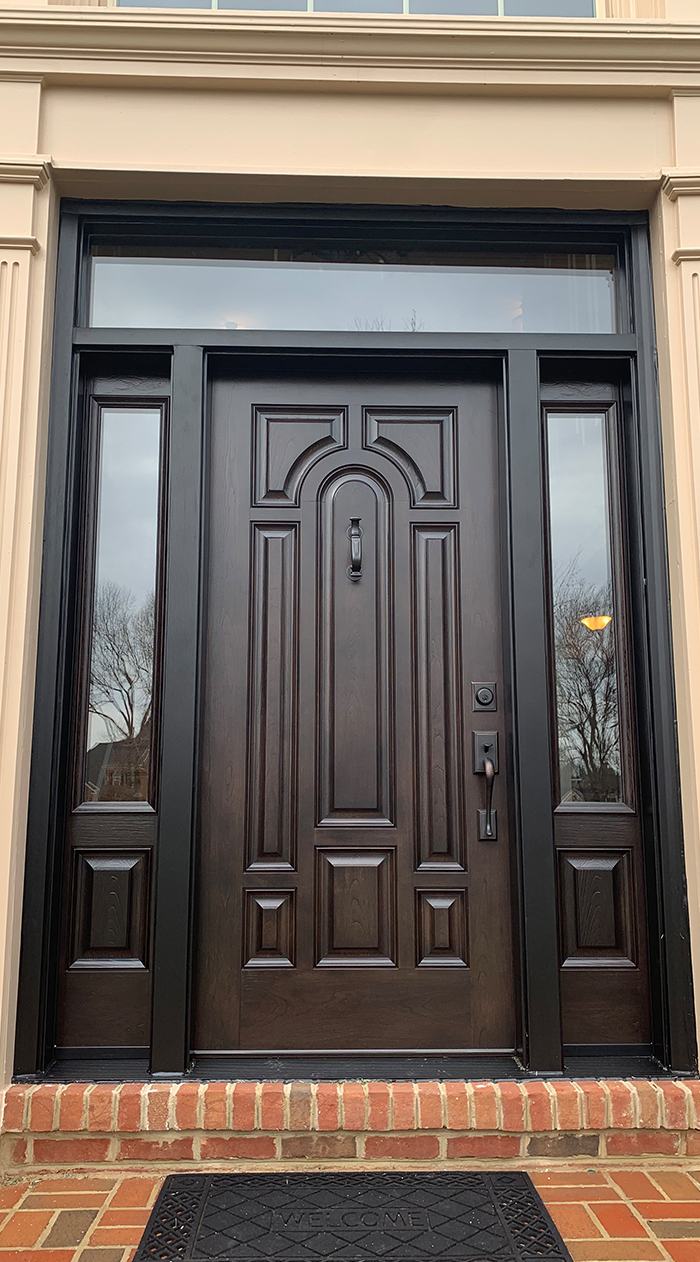 Dark brow front door with energy efficiencies windows on the sides of the frame