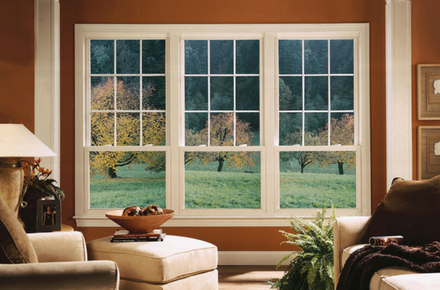 Three double-hung windows white-frame windows with triple-pane glass in a living room.
