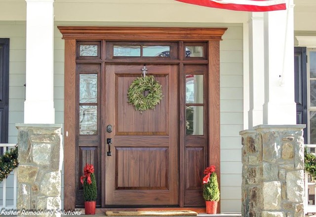 Wooden front door with surrounding rectangular windows.